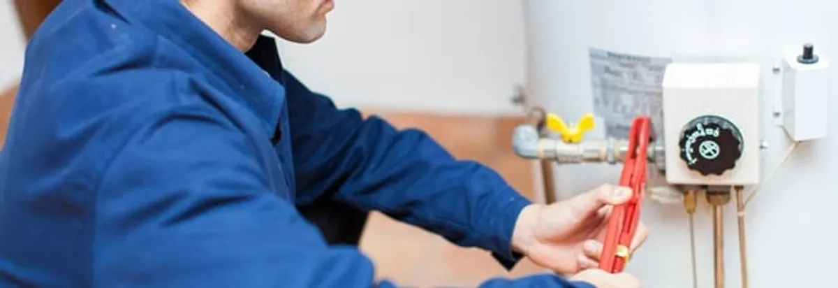 Water heater repair technician adjusting the temperature control and gas valve in Indianapolis, IN